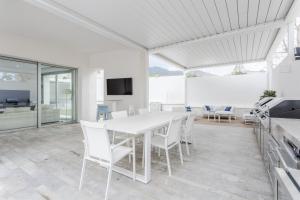 a white dining room with a white table and chairs at Villa Tritone in Palermo