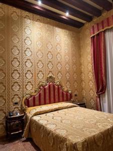 a bedroom with a bed with a red head board at Ca' San Zaccaria in Venice