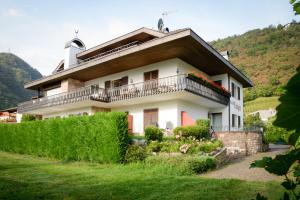 a house with a balcony on a hill at Pension Rebgut in Lana