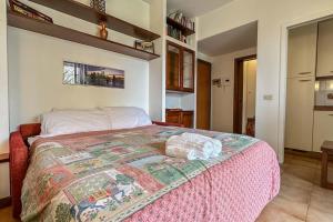 a bedroom with a large bed with a pink blanket at [10 minuti dall'aeroporto] Linate Studio Flat in Peschiera Borromeo