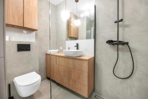 y baño con aseo, lavabo y ducha. en Lumina 2-room apartment with beautiful view Lodz en Lodz