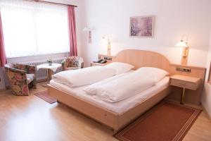 ein Schlafzimmer mit einem großen Bett und einem Stuhl in der Unterkunft Gasthof Isernhagen in Gödenstorf