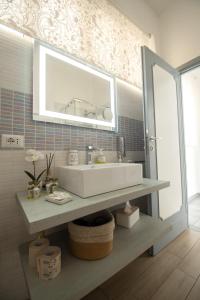 y baño con lavabo y espejo. en Casa Vacanze Family House posizione centralissima, en Civitavecchia