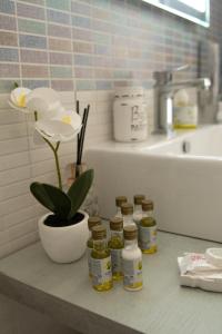 a bathroom counter with four jars of pickles and a flower at Casa Vacanze Family House posizione centralissima in Civitavecchia