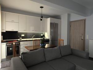 a living room with a couch and a kitchen at NP apartment in Neoi Epivates