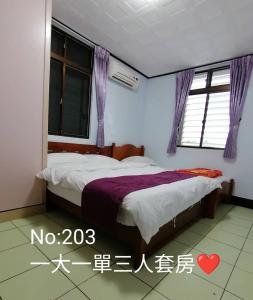 a bedroom with a bed with a purple blanket at B&G Crafs Art House in Chenggong
