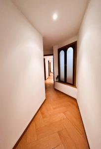 an empty room with a wooden floor and two windows at APARTAMENTOS TURISTICOS MONTASOL in Montánchez
