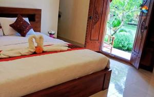 - un lit avec un animal farci dans une chambre dans l'établissement Dana guest house, à Ubud