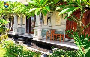 une chaise assise sur la terrasse couverte d'une maison dans l'établissement Dana guest house, à Ubud