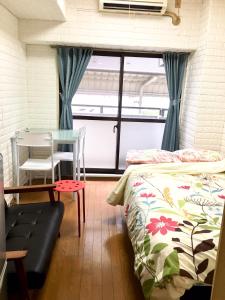 a room with two beds and a table and a window at 4 minute walk to station. Direct to Shibuya and Shinjuku in 35minutes in Nishi-tsuruma