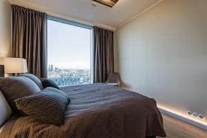 a bedroom with a bed and a large window at Luxurious, Skyline View Apartment near Centre in Tallinn