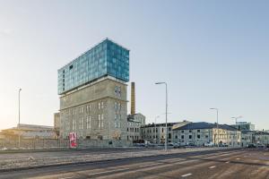 a tall glass building on the side of a street at Luxurious, Skyline View Apartment near Centre in Tallinn