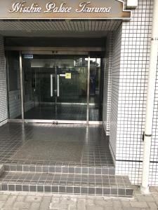 an entrance to a building with a glass door at 4 minute walk to station. Direct to Shibuya and Shinjuku in 35minutes in Nishi-tsuruma