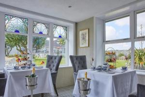 uma sala de jantar com duas mesas e janelas em County Arms Birr em Birr