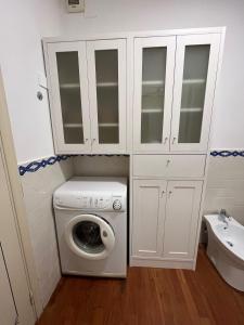 eine Waschmaschine im Bad mit einem weißen Schrank in der Unterkunft Appartamento Pianzola in Orvieto