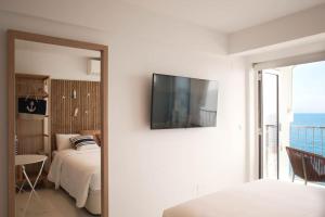 a bedroom with a bed and a television on a wall at Bambu Beach Studio by BHomesCostaBrava in Platja d'Aro
