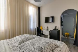 a bedroom with a bed and a desk and a mirror at Hôtel Henri IV in Tarbes