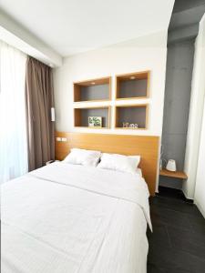 ティラナにあるMagnet Residence Condo 1 self checkinの白いシーツが敷かれた大きなベッドのある寝室