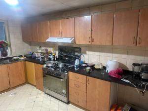 a kitchen with wooden cabinets and a stove top oven at Royal Suite: King Comfort in Ajman 