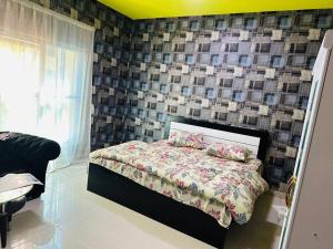 a bedroom with a bed and a wall with tiles at Royal Suite: King Comfort in Ajman 