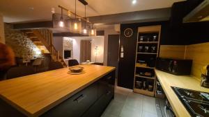 uma cozinha com um balcão de madeira num quarto em La casa cosy love, avec jacuzzi et sauna privés em Palau-del-Vidre