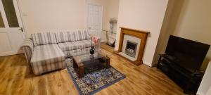 uma sala de estar com um sofá e uma lareira em Super Comfy & Family Friendly Home em Leigh