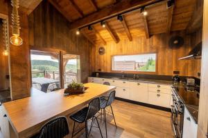 een keuken met een grote houten tafel en stoelen bij Chalet de standing, Jacuzzi, Sauna, Perle Noire in Gérardmer