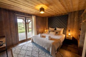 een slaapkamer met een bed en een groot raam bij Chalet de standing, Jacuzzi, Sauna, Perle Noire in Gérardmer