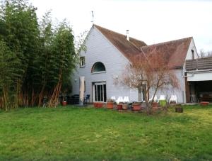 een wit huis met een tuin ervoor bij Le Coin Du Bois En Touraine in Château-la-Vallière