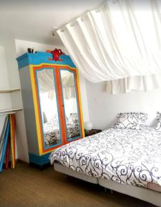 een slaapkamer met een bed, een dressoir en een spiegel bij Le Coin Du Bois En Touraine in Château-la-Vallière