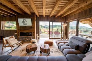 a living room with a couch and a fireplace at Chalet de standing, Jacuzzi, Sauna, Perle Noire in Gérardmer