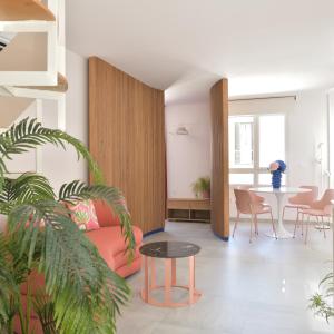 sala de estar con sofá rosa y mesa en PATIO de SOMBRA · Urban Suites, en Granada
