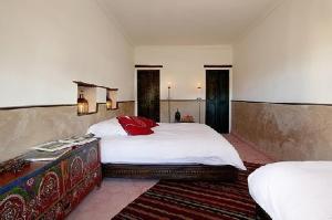 a bedroom with two beds with white sheets and red pillows at Dar Sihamou in Tabant +54 photos