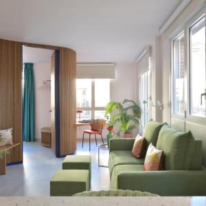 una sala de estar con 2 sofás verdes y una mesa. en PATIO de SOMBRA · Urban Suites, en Granada