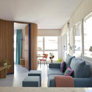 sala de estar con sofá azul y mesa en PATIO de SOMBRA · Urban Suites, en Granada