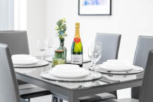 una mesa de comedor con una botella de vino y copas en Luxury 4 Bedroom House - Harborne - Top Rated - Parking - Garden - 6CO en Birmingham