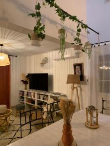 a living room with a table with a desk with a tv at La villa Pausa en Drôme provençale in Montboucher-sur-Jabron