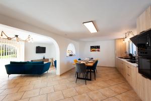 a kitchen and living room with a blue couch and a table at Gîte Cerise - Maison climatisée avec piscine in Istres