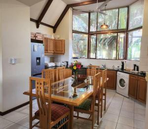 a kitchen with a glass table and wooden chairs at Villa G5 - Selborne Golf Estate in Pennington