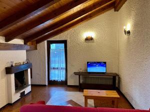 sala de estar con sofá y mesa con TV en Val di Sole Apartment, en Monclassico