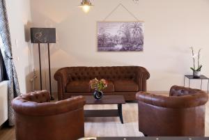 a living room with a couch and two chairs at Domaine de la Noiseraie in Belleville-sur-Saône