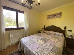 een slaapkamer met een bed en een groot raam bij Casa El Molín 1 Soto de Dueñas in Arriondas