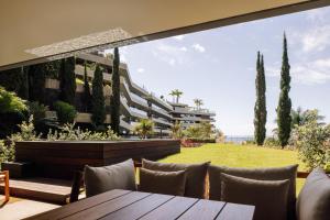 eine Terrasse mit einem Tisch und Stühlen sowie ein Gebäude in der Unterkunft Saccharum - Resort and Spa - Savoy Signature in Calheta