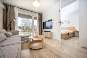 a living room with a couch and a bed and a table at SMILGA & KOPA home - Mano jūra 2 Kunigiškiai - by Hello Sea homes in Palanga