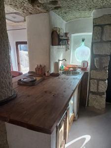 a kitchen with a wooden counter top and a sink at Riolit Barlangszállás Szomolya in Szomolya