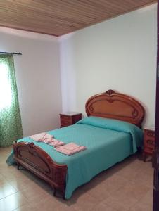 a bedroom with a bed with a green comforter at Casa Pancha in Garafía
