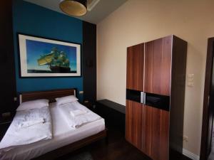een slaapkamer met een bed en een houten kast bij Apartament Piwna IV in Gdańsk