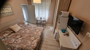 um pequeno quarto de hotel com uma cama e uma televisão em La Casa di Mimmo em Gradara