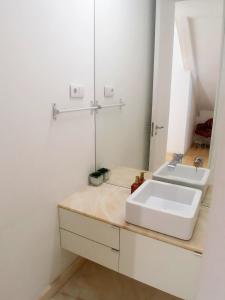 uma casa de banho com um lavatório branco e um espelho. em Be Local - 2 bedrooms in front of the Fado Museum in Alfama em Lisboa