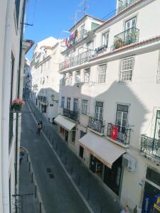 リスボンにあるBe Local - 2 bedrooms in front of the Fado Museum in Alfamaの白い建物のある街の空き通り